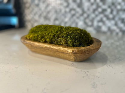 Angled view of hand-carved wooden bowl with preserved dark green pillow moss mounds.