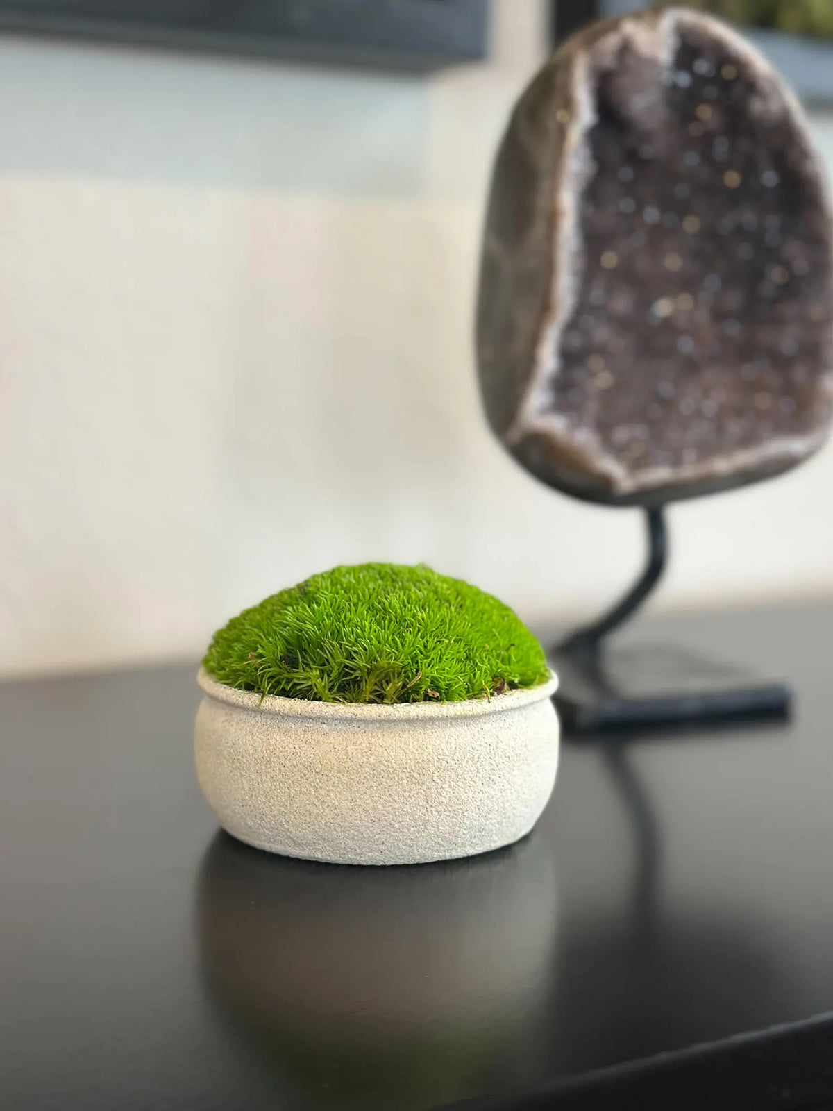 Mini upcycled beige textured bowl with preserved light green moss displayed on a black tabletop